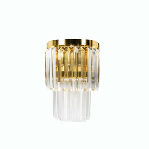 May include: A gold and crystal wall sconce with a geometric design. The sconce has two tiers of crystal prisms.