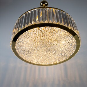 Pu&ograve; includere: Un lampadario rotondo in cristallo dorato. Il lampadario ha un design moderno ed &egrave; perfetto per aggiungere un tocco di eleganza a qualsiasi stanza.