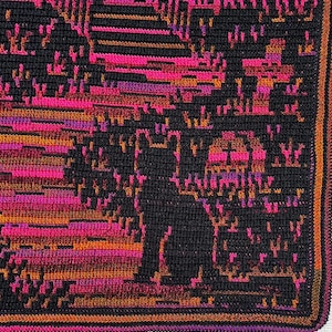 Op de afbeelding: Een gehaakte deken met een zwart katten silhouet tegen een levendige achtergrond. Het ontwerp bevat tinten roze, oranje en paars, waardoor een gepixeleerd effect ontstaat. De deken heeft een donkere rand.