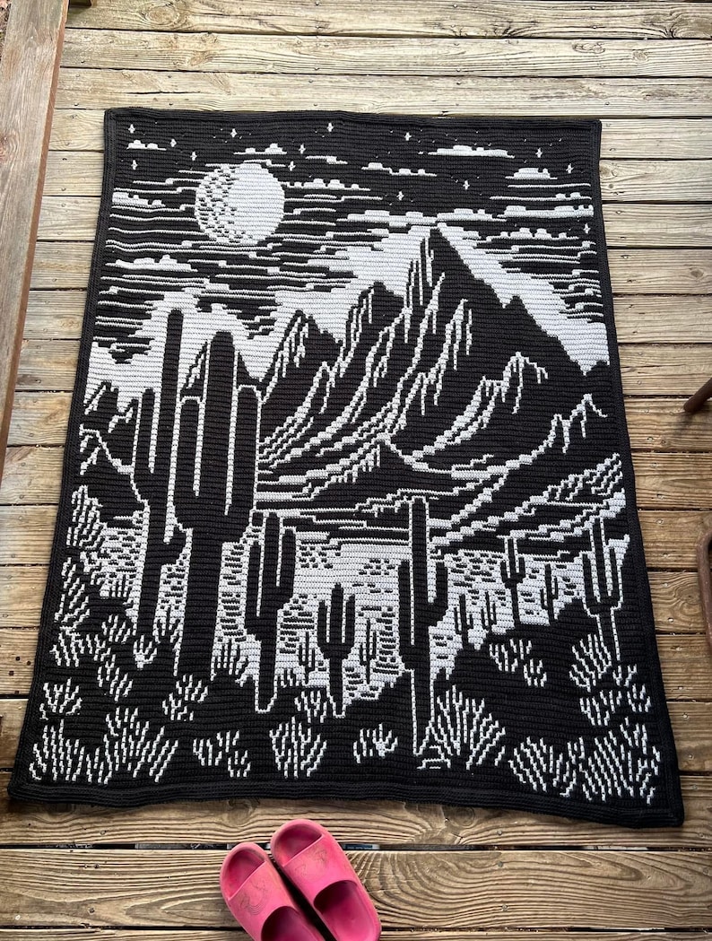 Peut inclure: Couverture en crochet noir et blanc avec un motif de paysage d&eacute;sertique. La couverture repr&eacute;sente une cha&icirc;ne de montagnes, une pleine lune et des cactus.