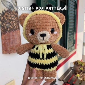 May include: A handmade brown bear plushie wearing a yellow and black striped bee costume. The bear has a yellow hood and black antennae. The text "DIGITAL PDF PATTERN!!" is visible at the top of the image.