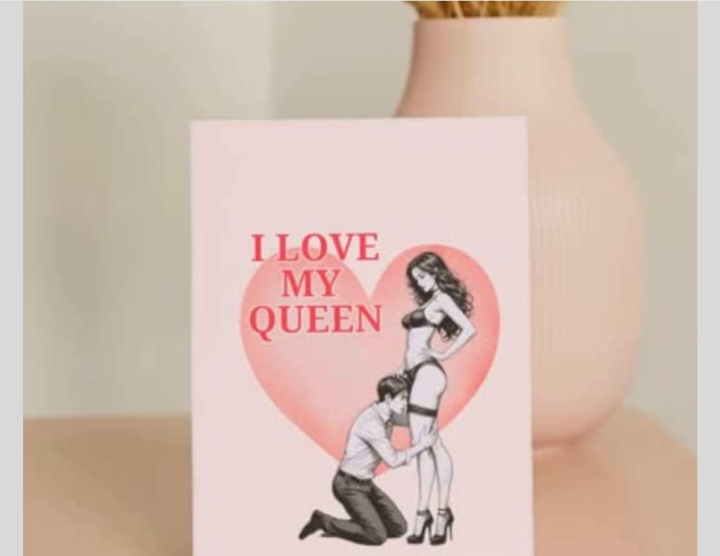 May include: A greeting card with the text "I LOVE MY QUEEN" in red letters. The card features an illustration of a woman in lingerie and a man kneeling before her, set against a pink heart.