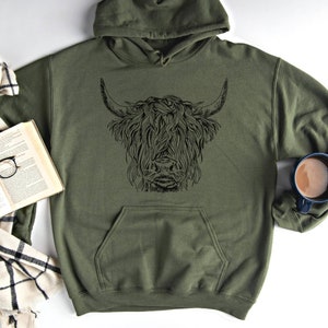 May include: A green hooded sweatshirt with a black graphic of a Highland cow's head.