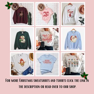 May include: Collection of Christmas-themed sweatshirts and t-shirts. Designs include Santa Claus, reindeer, and festive text. Colors vary from burgundy to light blue and grey. The text "Merry Christmas" is featured on several items. The image also includes the text: "FOR MORE CHRISTMAS SWEATSHIRTS AND TSHIRTS CLICK THE LINK IN THE DESCRIPTION OR HEAD OVER TO OUR SHOP."