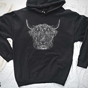 May include: Black hooded sweatshirt with a white graphic print of a Highland cow's head.
