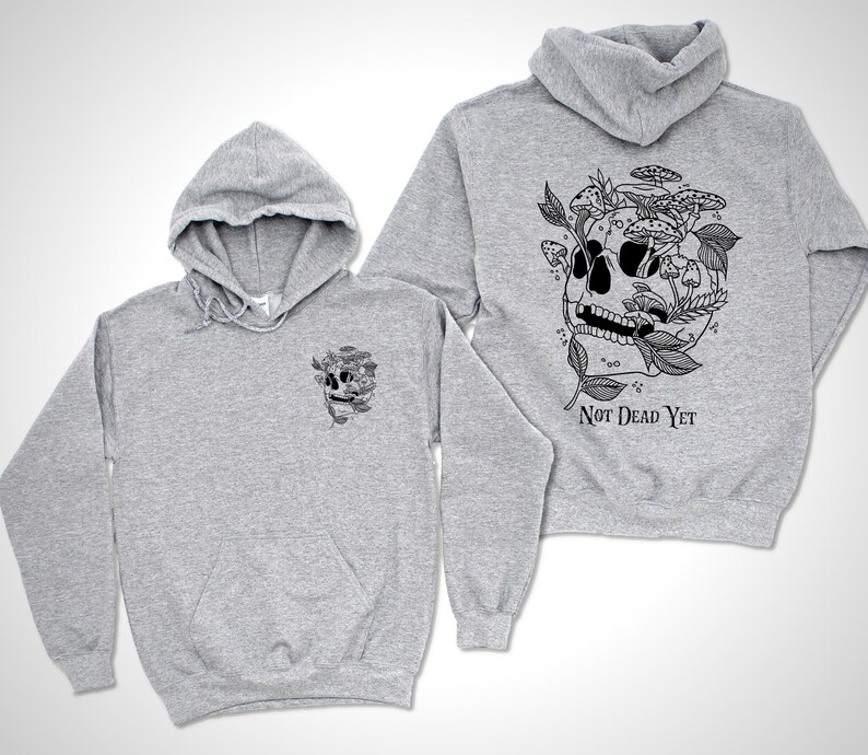 May include: Two light gray hoodies with a black graphic of a skull with mushrooms and leaves. The back of one hoodie has the text "Not Dead Yet" below the skull design. The other hoodie has the same skull design on the front.