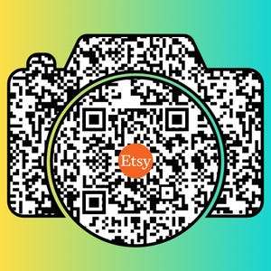 May include: Black and white QR code with a circle around it. The circle is green on the outside and white on the inside. The word "Etsy" is written in orange inside the circle.