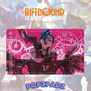 Puede incluir: Una alfombrilla de juego rosa y negra de Riftbound League of Legends para juegos de cartas coleccionables. Presenta un personaje con cabello azul y una pistola, con texto y números blancos. El logotipo de Popzpadz está en la parte inferior.