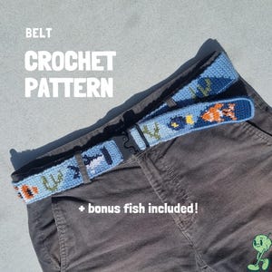 May include: Crochet belt pattern with a blue background and colorful fish and plant designs. The belt is displayed on a pair of brown pants. Text on the image reads "BELT CROCHET PATTERN + bonus fish included!"