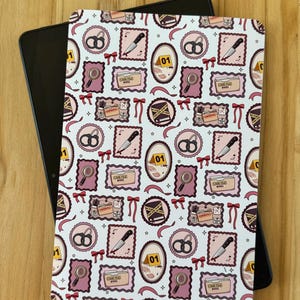 May include: A tablet case featuring a repeating pattern of crime scene investigation icons including handcuffs, knives with blood, magnifying glasses, evidence markers labeled 01, and folders marked Case File #0001, all framed by red bows.