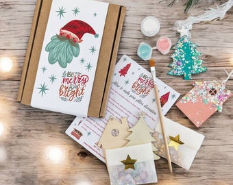 May include: A Christmas craft kit with wooden ornaments shaped like a house and a tree. The kit includes paint, glitter, and instructions on how to make your own glitter decorations. The box is decorated with a festive gnome and the words "Be merry & bright".