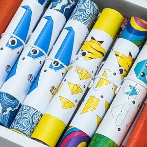 Peut inclure: Un ensemble de rouleaux de papier origami color&eacute;s avec des instructions pour plier diff&eacute;rentes formes. Le papier est imprim&eacute; avec diff&eacute;rents motifs, notamment des vagues, des rayures et un arc-en-ciel.