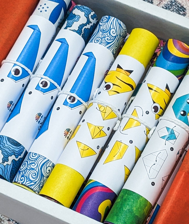 Peut inclure: Un ensemble de rouleaux de papier origami color&eacute;s avec des instructions pour plier diff&eacute;rentes formes. Le papier est imprim&eacute; avec diff&eacute;rents motifs, notamment des vagues, des rayures et un arc-en-ciel.