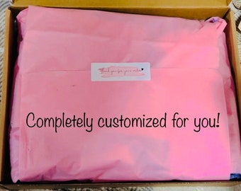 May include: A pink tissue paper-lined box with the text "Completely customized for you!" and a small sticker that says "Thank you for your order".