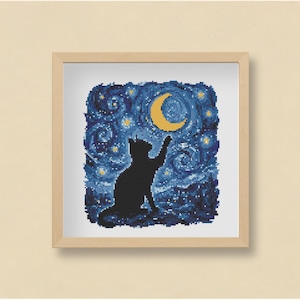 May include: Framed cross-stitch art depicting a black cat silhouette reaching for a yellow crescent moon against a swirling blue and yellow starry night sky. The artwork is in a light brown wooden frame.