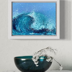 May include: A framed painting of a large blue wave crashing in the ocean. The wave is painted with thick brushstrokes and has a white crest. The background is a light blue sky with white splashes of paint.