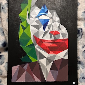 May include: Geometric painting of a clown's face with a black background. The clown's face is composed of triangular shapes in shades of gray, white, red, green, and blue. The clown's lips are red, and the background is black.