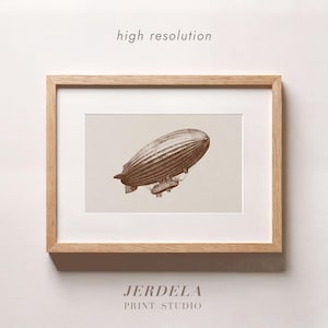 May include: A sepia-toned print of a vintage airship, framed in a light wood. The image features a detailed illustration of a zeppelin, with the words "high resolution" at the top and "JERDELA PRINT STUDIO" at the bottom.