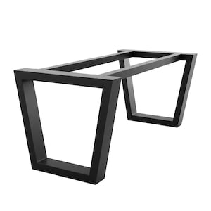 Puede incluir: Base de mesa de metal negro con una parte superior rectangular y patas anguladas. La base está hecha de metal resistente y tiene un acabado negro.