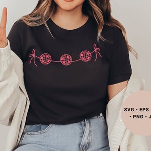 May include: A black t-shirt with a pink design of disco balls connected by string. The text "SVG - EPS - DXF - PNG - JPG" is in a pink circle on the right side of the image.