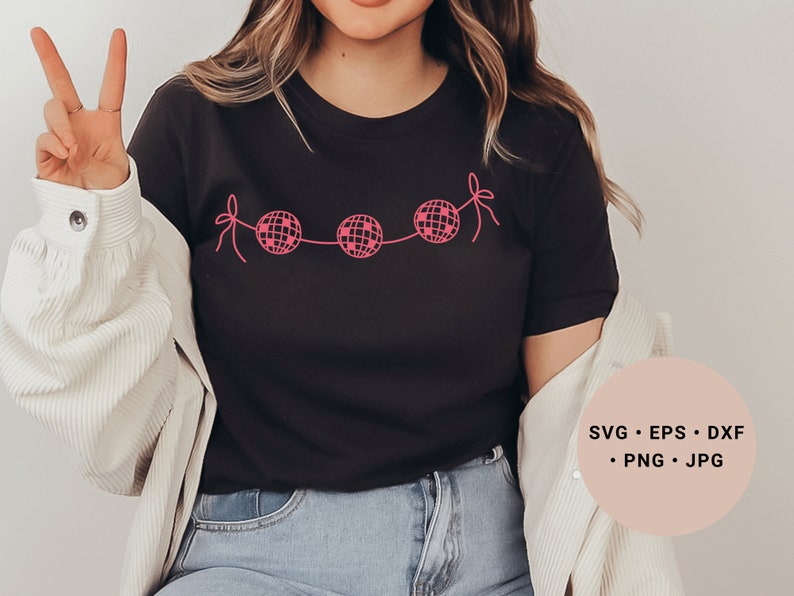May include: A black t-shirt with a pink design of disco balls connected by string. The text "SVG - EPS - DXF - PNG - JPG" is in a pink circle on the right side of the image.