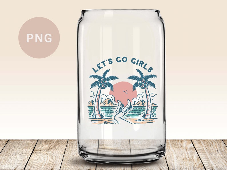 K&ouml;nnte beinhalten: Klares Trinkglas in Dosenform mit Strandmotiv. Das Design umfasst Palmen, einen Sonnenuntergang und den Text "LET'S GO GIRLS". Das Glas steht auf einer Holzoberfl&auml;che.