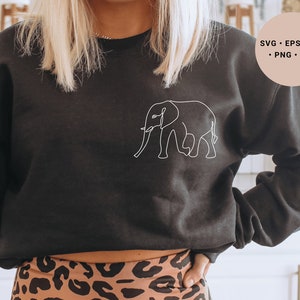 Könnte beinhalten: Ein schwarzes Sweatshirt mit einer weißen Linienzeichnung eines Elefanten auf der Vorderseite. Das Sweatshirt wird von einer Person mit langen blonden Haaren getragen und zu einer Leoparden-Leggings kombiniert.