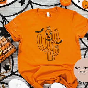May include: Orange t-shirt featuring a black graphic of a cactus with a jack-o'-lantern face. The cactus is surrounded by bats and stars. The text "SVG - EPS - DXF - PNG - JPG" is in the bottom right corner of the image.