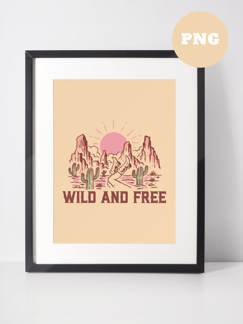 Puede incluir: Una impresi&oacute;n enmarcada con una ilustraci&oacute;n de paisaje des&eacute;rtico. La impresi&oacute;n presenta un sol rosa, monta&ntilde;as, cactus y un camino sinuoso. El texto "WILD AND FREE" est&aacute; impreso debajo de la imagen.