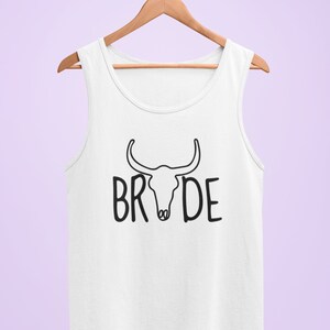 May include: White tank top with a black bull skull graphic and the word "BRIDE" printed below it.