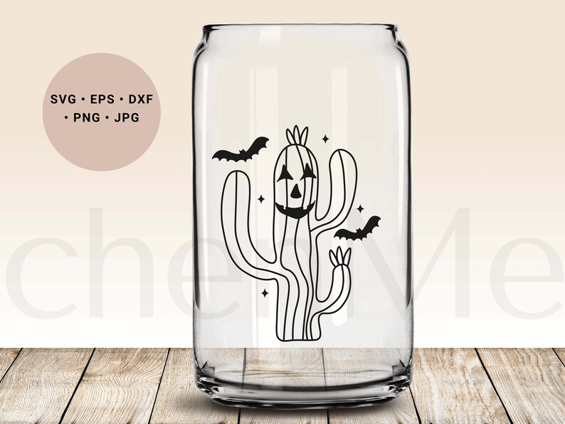 May include: A black and white illustration of a cactus with a jack-o'-lantern face and two bats flying around it. The cactus is on a clear glass can.