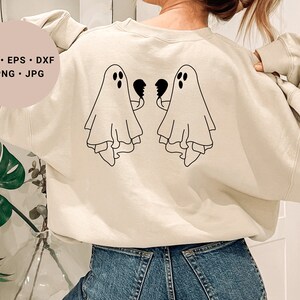 May include: A cream-coloured sweatshirt with a black outline of two ghosts holding broken hearts on the back. The text "SVG - EPS - DXF - PNG - JPG" is on a pink circle in the top left corner of the image.
