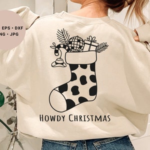 Könnte beinhalten: Ein weißer Pullover mit einer schwarz-weißen Illustration eines mit Weihnachtsartikeln gefüllten Strumpfes. Der Text "Howdy Christmas" ist unter dem Strumpf gedruckt.