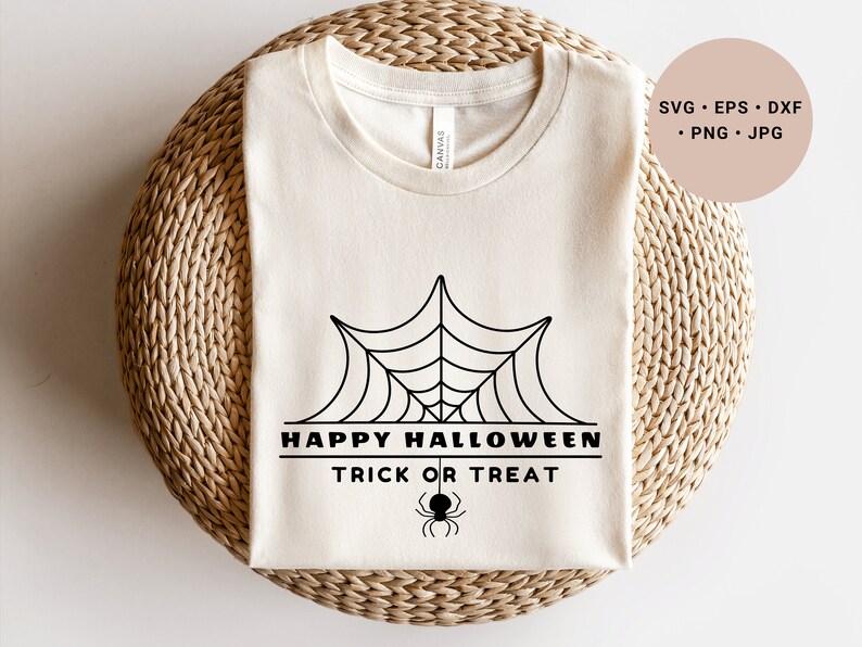 K&ouml;nnte beinhalten: Ein wei&szlig;es T-Shirt mit einem schwarzen Spinnennetz-Design und dem Text "Happy Halloween Trick or Treat".