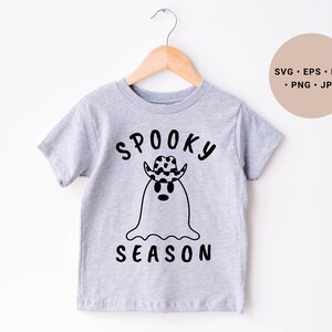 May include: A gray t-shirt with a black and white ghost wearing a cowboy hat and the text "Spooky Season".