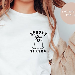May include: A white t-shirt with a black and white illustration of a ghost wearing a cowboy hat. The text "Spooky Season" is written above the ghost.