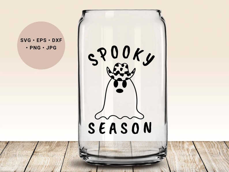 May include: A clear glass can with a black and white design of a ghost wearing a cowboy hat. The text "Spooky Season" is printed below the ghost.
