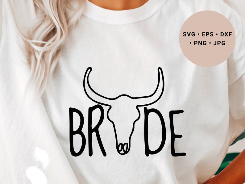 May include: White t-shirt with a black outline of a bull skull and the word "BRIDE" written in a stylized font.