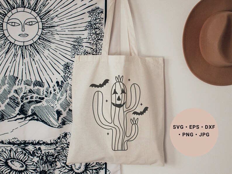 May include: A white tote bag featuring a black line drawing of a cactus with a jack-o'-lantern face and bats flying around it. The text "SVG - EPS - DXF - PNG - JPG" is printed on a pink circle in the bottom right corner of the image.