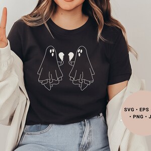 May include: A black t-shirt featuring a white graphic of two ghosts holding broken hearts. The text "SVG - EPS - DXF - PNG - JPG" is on a pink circle in the bottom right corner of the image.