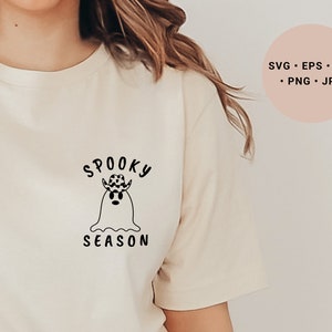 May include: A white t-shirt with a black graphic of a ghost wearing a cowboy hat and the text "Spooky Season".