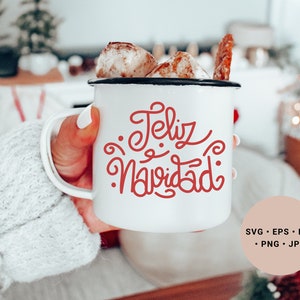 May include: White ceramic mug with a red cursive design that says "Feliz Navidad". The mug is filled with a hot beverage and marshmallows.