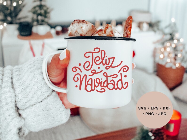 May include: White ceramic mug with a red cursive design that says "Feliz Navidad". The mug is filled with a hot beverage and marshmallows.