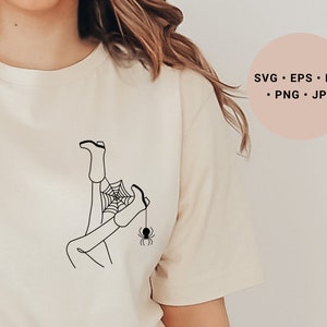 May include: A black and white line drawing of a person's legs tangled in a spider web with a spider hanging from the web. The design is on a white t-shirt.