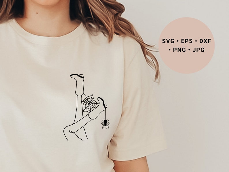 May include: A black and white line drawing of a person's legs tangled in a spider web with a spider hanging from the web. The design is on a white t-shirt.