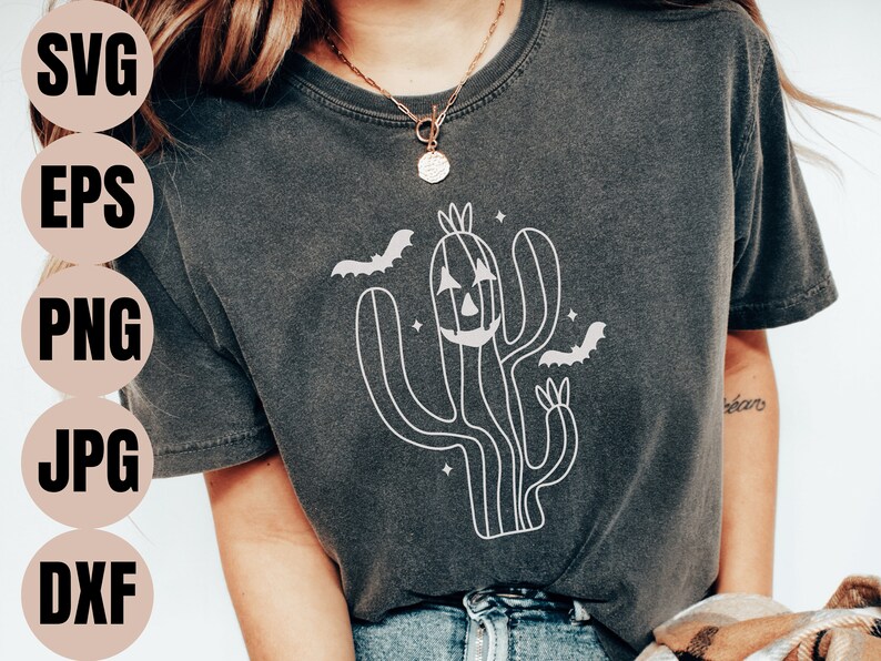 May include: A dark grey t-shirt featuring a white outline of a cactus with a jack-o'-lantern face and bats flying around it.