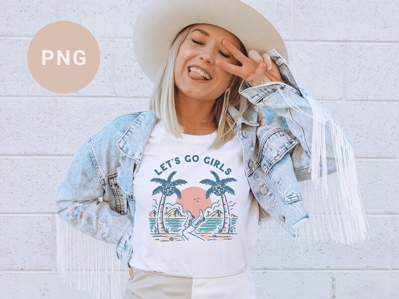 K&ouml;nnte beinhalten: Wei&szlig;es T-Shirt mit dem Text "LET'S GO GIRLS" und einer Strandgrafik. Die Grafik zeigt Palmen, einen Sonnenuntergang und eine Person. Die Person tr&auml;gt einen Hut und eine Jeansjacke.