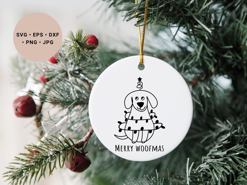 May include: White ceramic Christmas ornament with a black line drawing of a dog wearing Christmas lights and a star on top of its head. The text "Merry Woofmas" is printed below the dog.