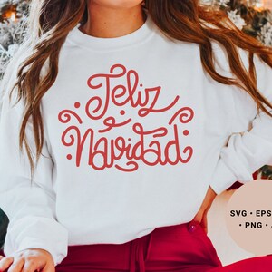 May include: White sweatshirt with red lettering that says "Feliz Navidad".