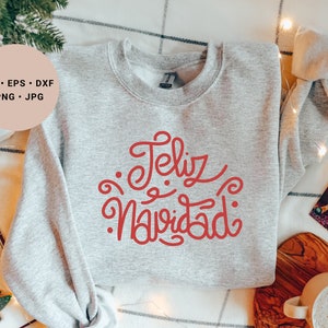 May include: A gray sweatshirt with the text "Feliz Navidad" in red cursive lettering.